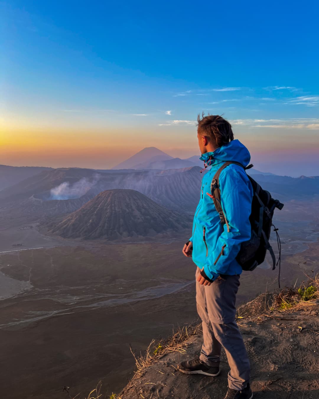 Amanecer-monte-bromo-nubes-sol-naranja-azul-persona-volcan