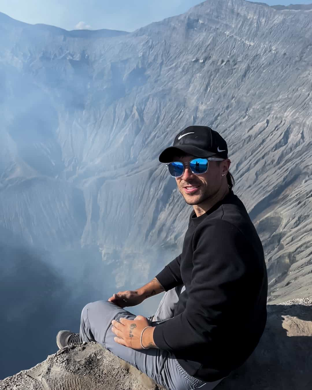 Persona-Sentada-borde-crater-volcan-humo